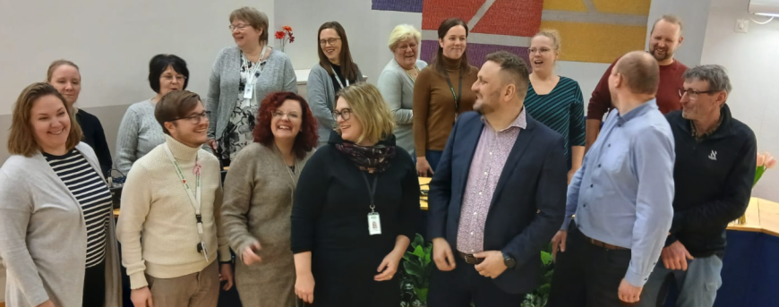 Henkilökuntaa ryhmäkuvassa.